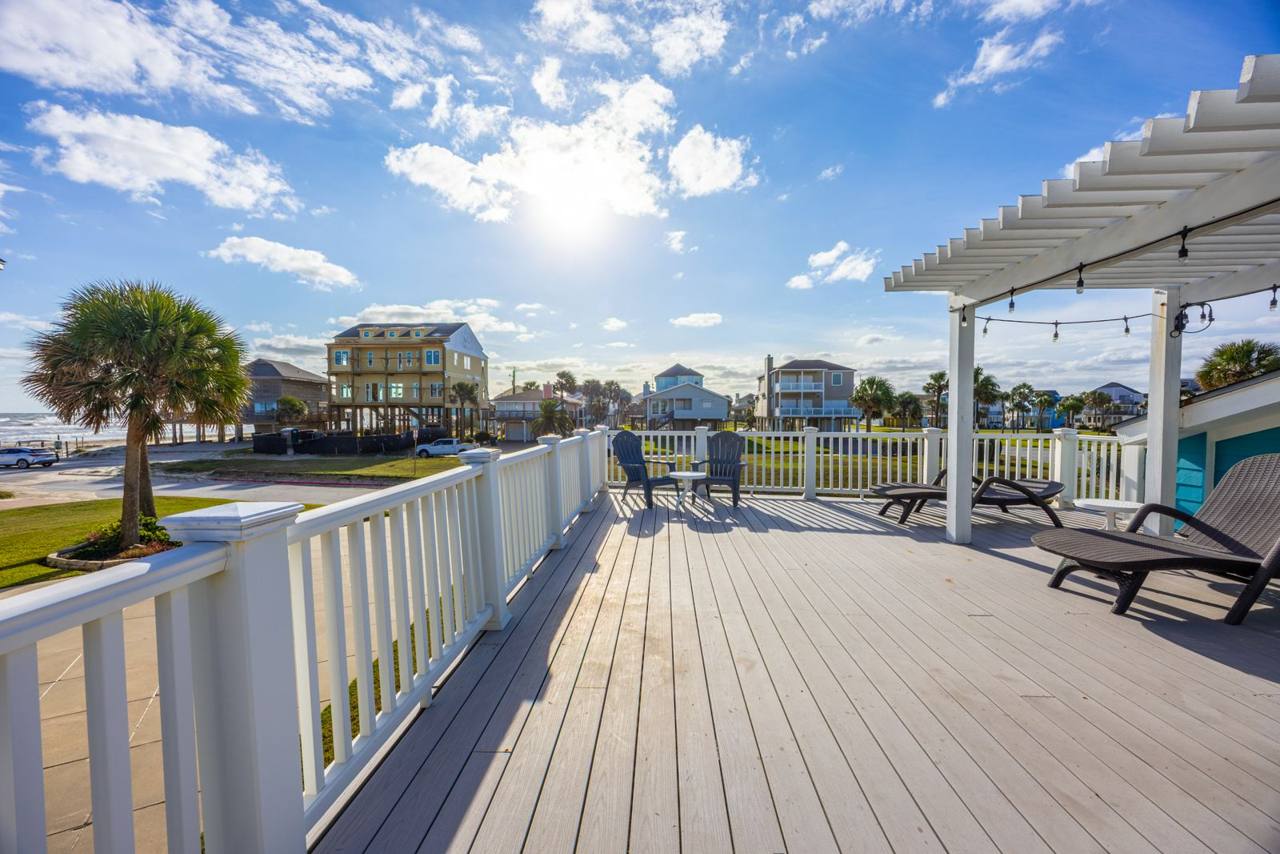 Wide deck with Adirondack chairs and the Gulf in view down the street