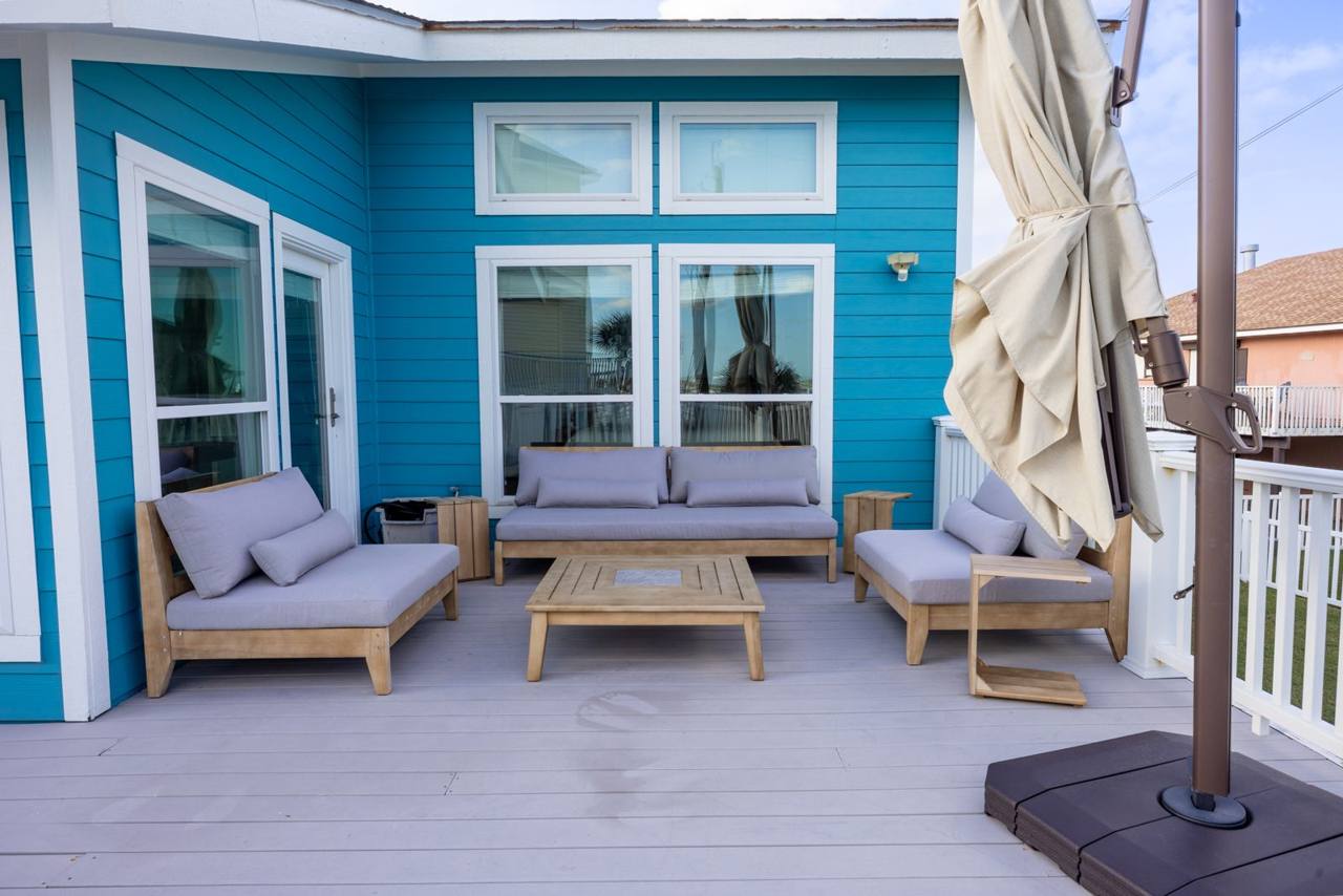 Outdoor lounge area on the deck with cushioned seating and a patio umbrella