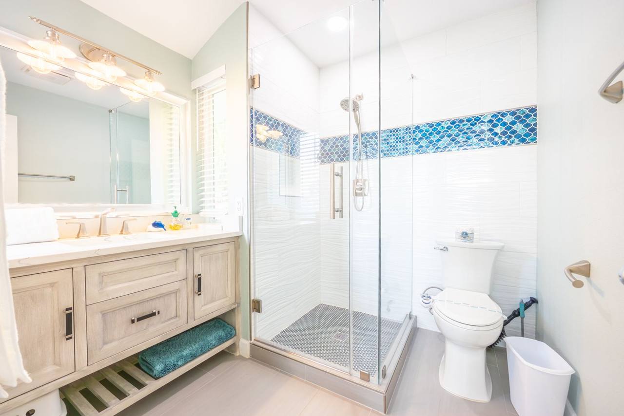 Bathroom with a glass-enclosed walk-in shower and blue mosaic accent tile
